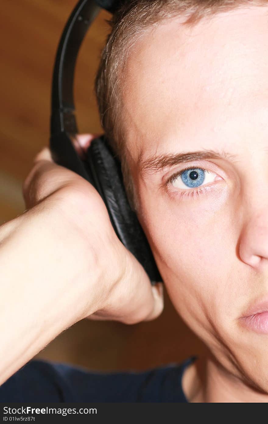 Male with blue eyes looking at you and listening to his headphones. Male with blue eyes looking at you and listening to his headphones