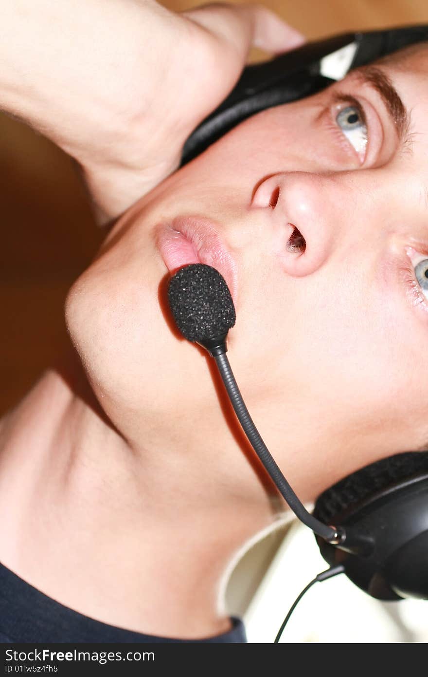 Male having a pair of black headphones on him. looking in to the distance. Male having a pair of black headphones on him. looking in to the distance