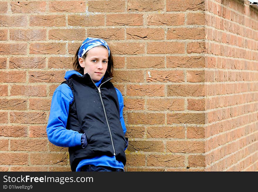 Teenage girl against brick wall