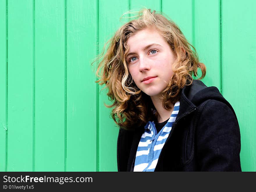 Pretty teenage girl against green wall