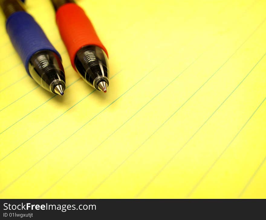 Red and Blue Pens on Yellow Pad of Paper. Red and Blue Pens on Yellow Pad of Paper