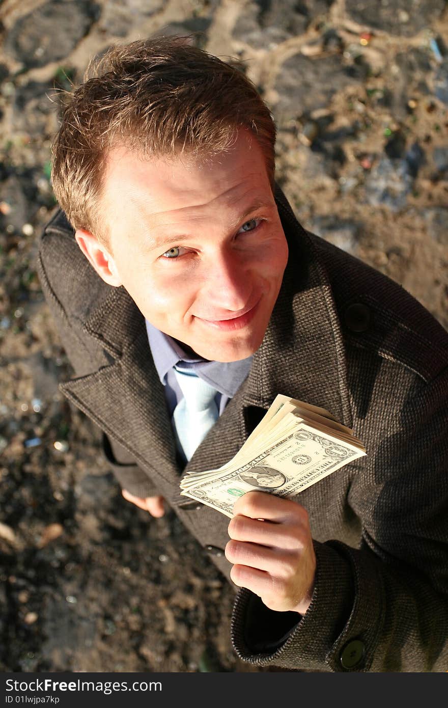 Businessman showing bundle of dollars into the camera. Businessman showing bundle of dollars into the camera