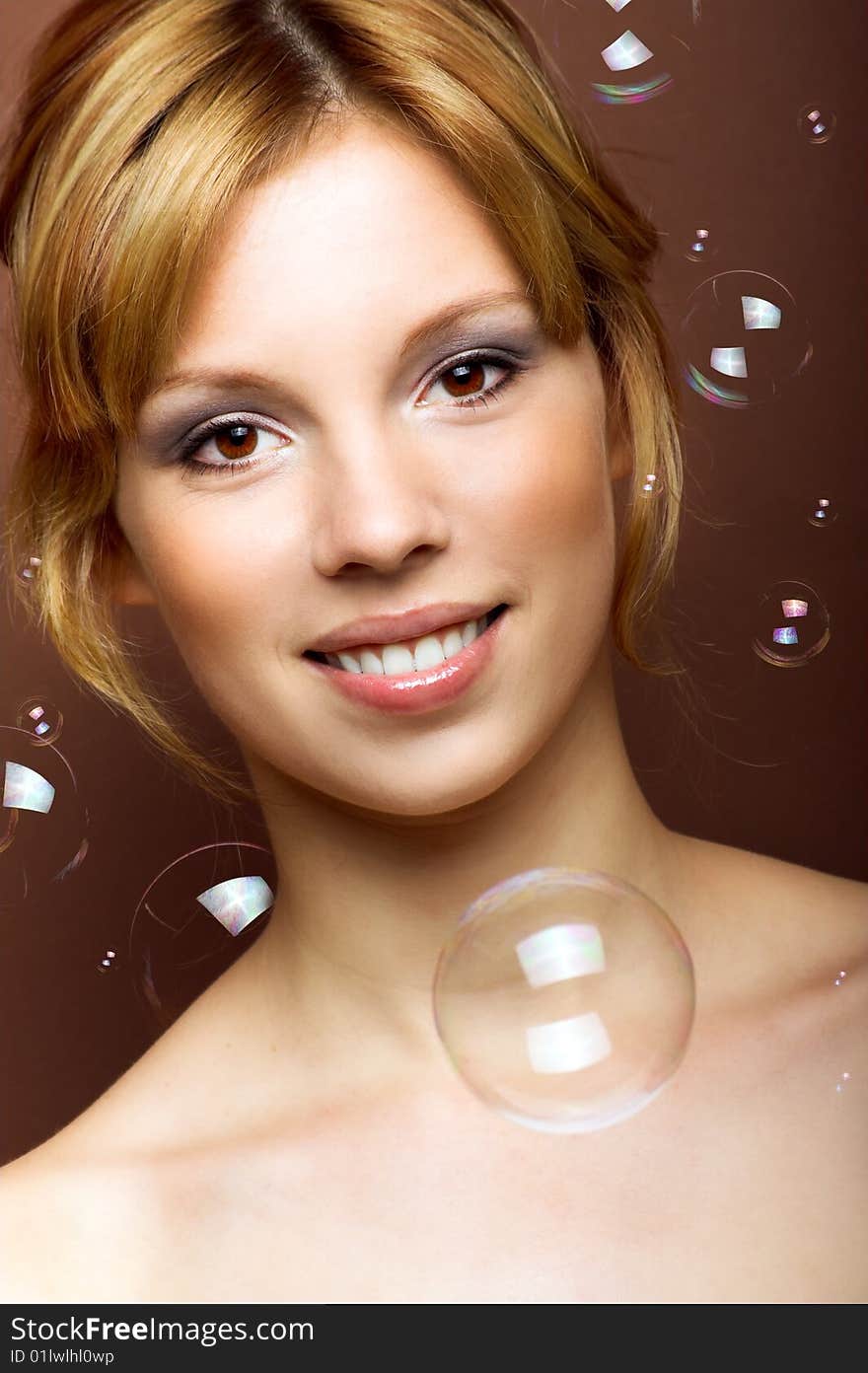 Beauty portrait of a young smiling woman with soap bubbles. Beauty portrait of a young smiling woman with soap bubbles