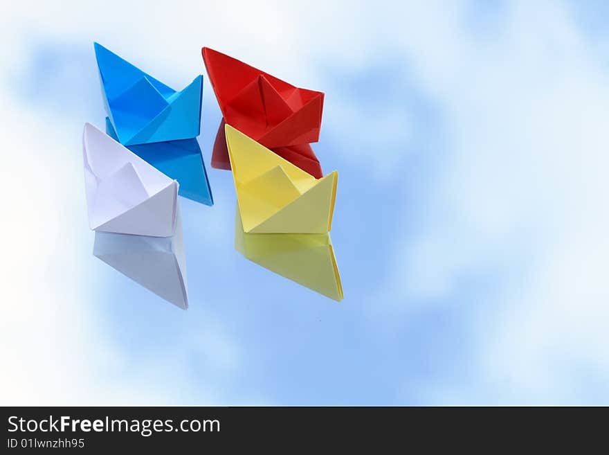 Colorful paper boats isolated on background with blue sky. Colorful paper boats isolated on background with blue sky