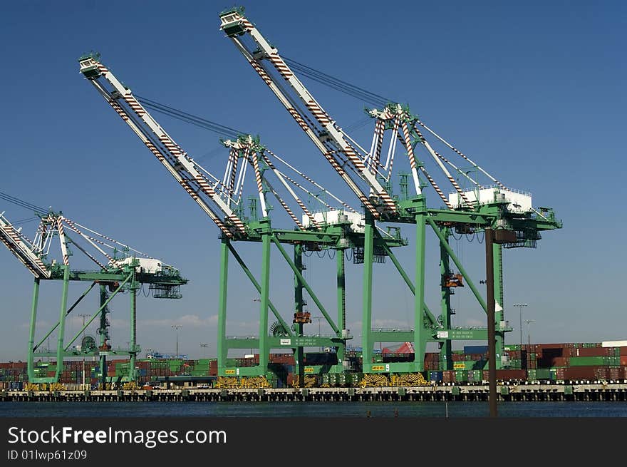 Large, modern cargo cranes are used to load container ships arriving at the port. Large, modern cargo cranes are used to load container ships arriving at the port.