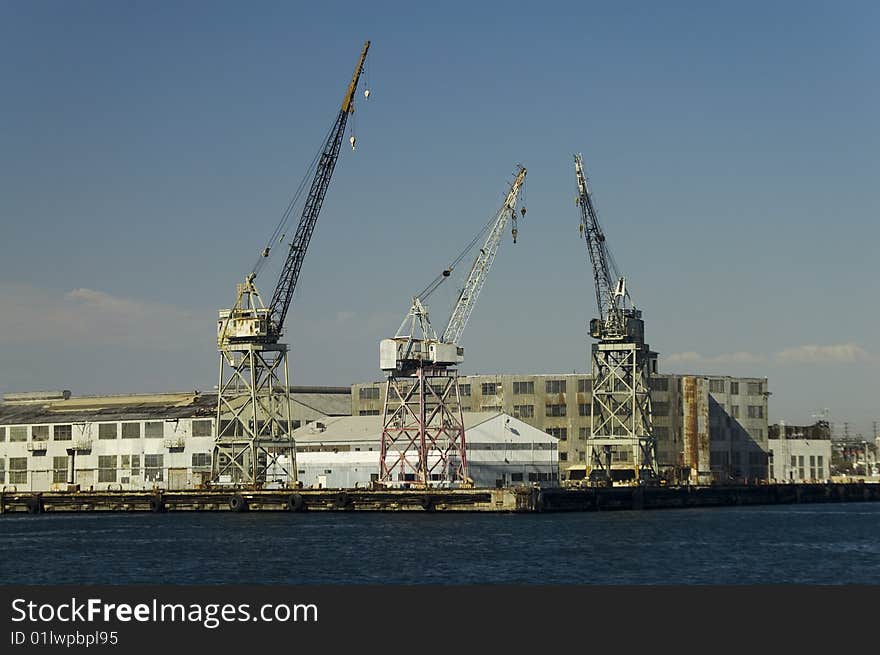 Old style cargo cranes of the type used to move bulk cargo from ships. Old style cargo cranes of the type used to move bulk cargo from ships.