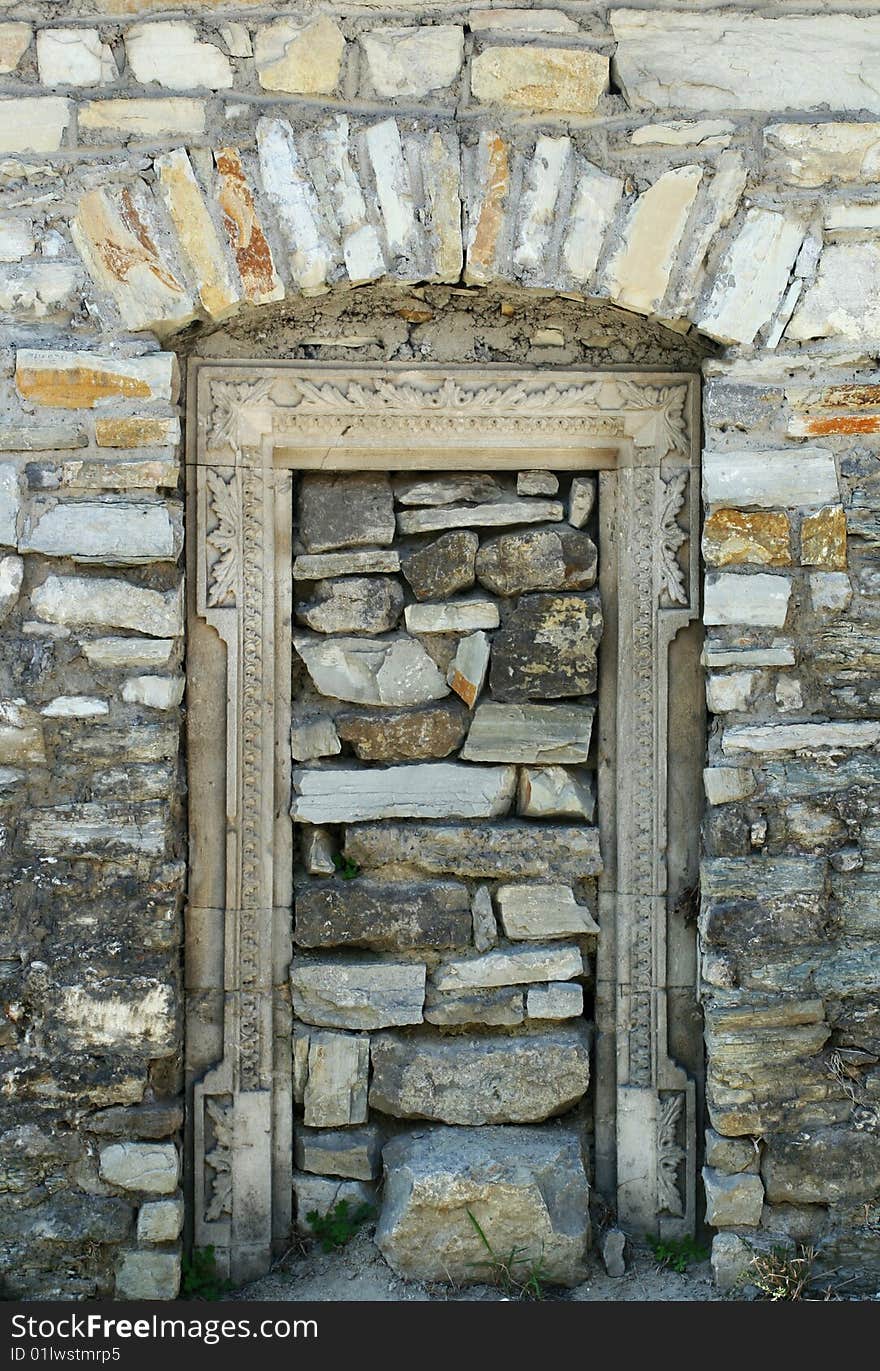 Input at an ancient door immured by stones.