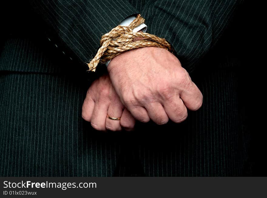 A horizontal view of a business man with his hands tied infront of him. Concept:My hands are tied