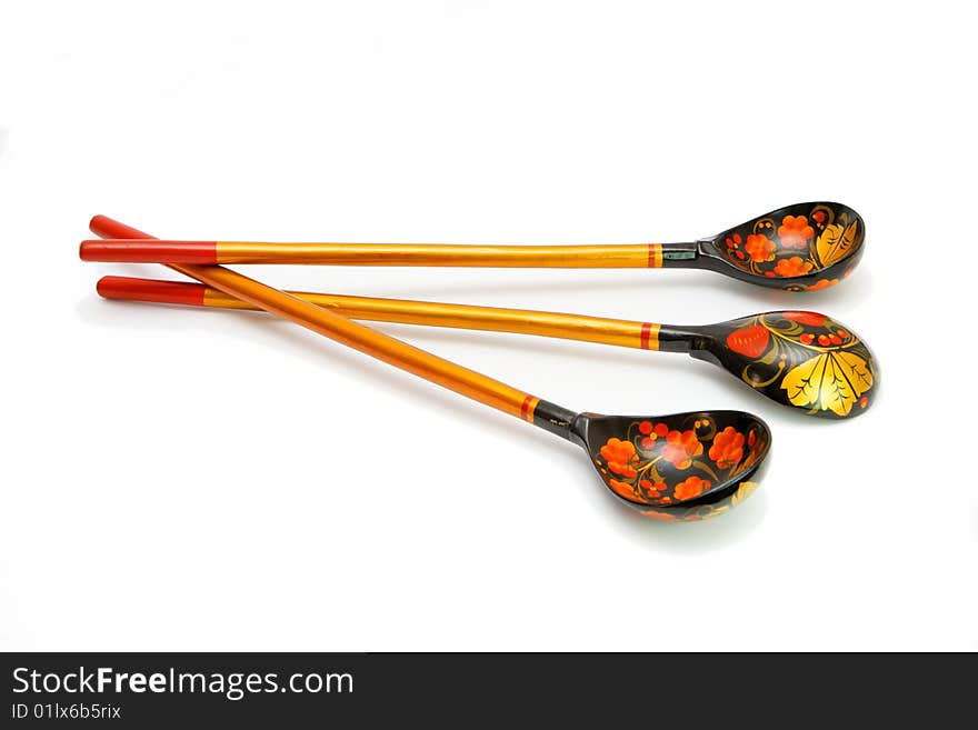 Three Russian wooden hand-painted spoons with long handles on white background. Three Russian wooden hand-painted spoons with long handles on white background