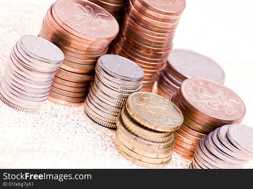 Piles of various coins arranged on gold backing. Piles of various coins arranged on gold backing