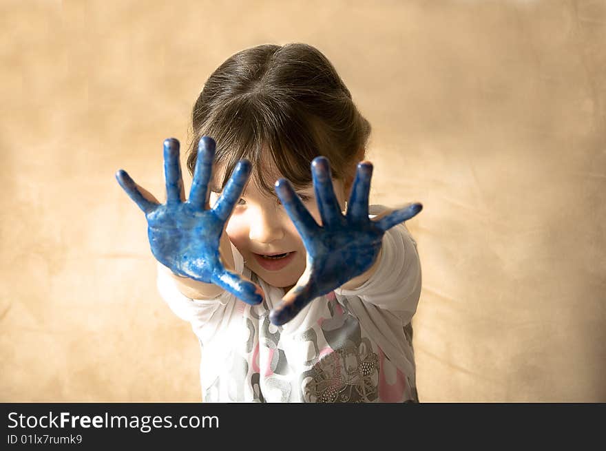 Girl with hands painted in blue paints ready for hand prints. Girl with hands painted in blue paints ready for hand prints.