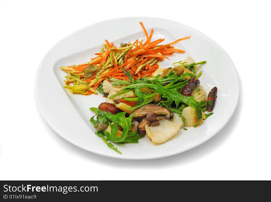 Octopus with mushrooms, orange carrot and green seaweed on the white plate. Octopus with mushrooms, orange carrot and green seaweed on the white plate