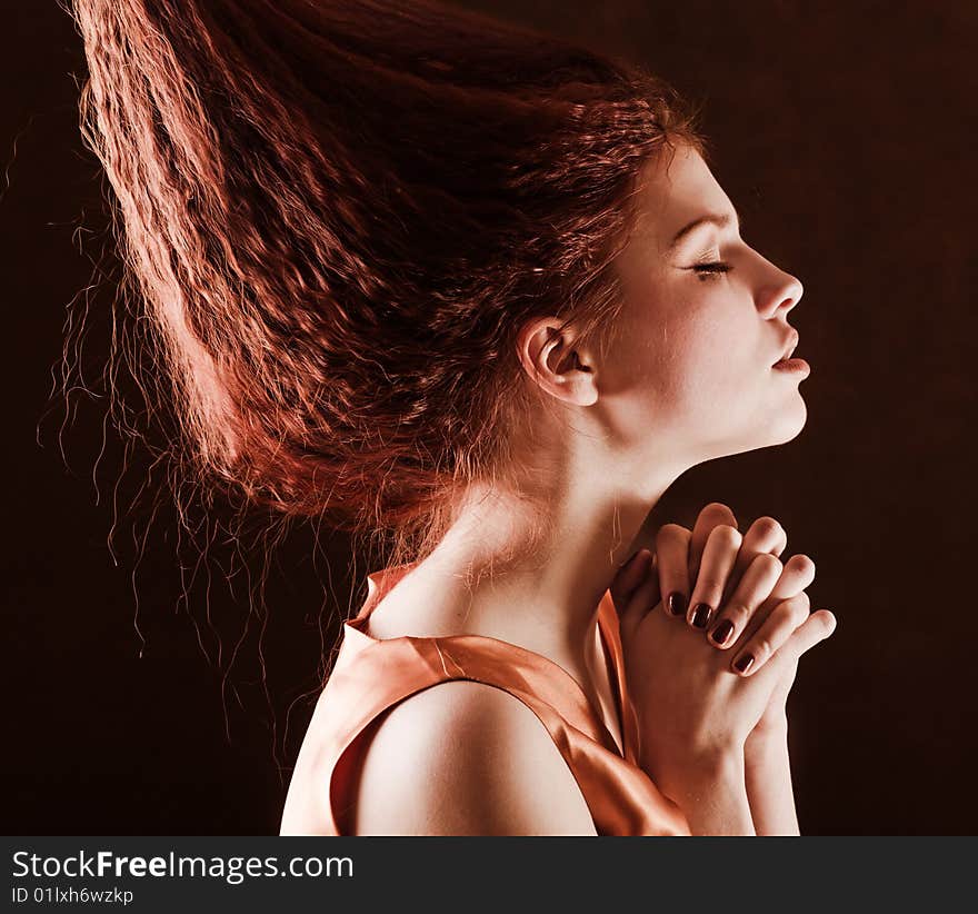 Young pretty girl with red hair is praying. Young pretty girl with red hair is praying