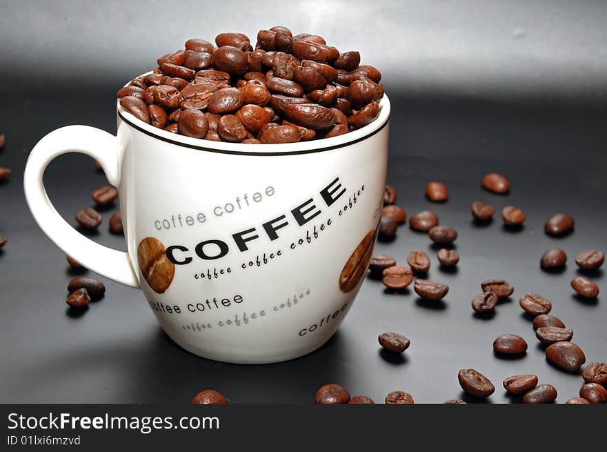 Grains of coffee in a coffee cup on a black background