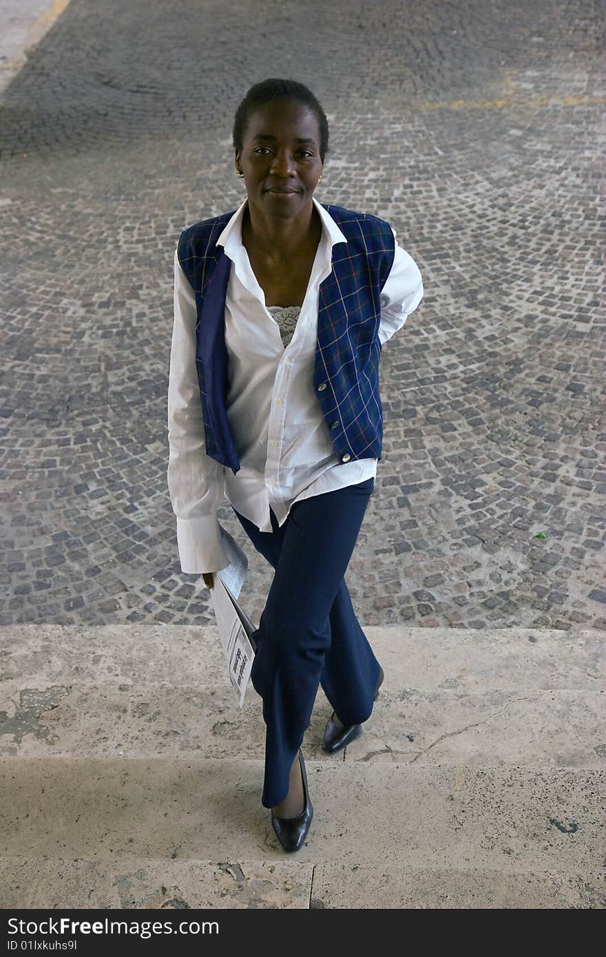 French model reading a newspaper while walking