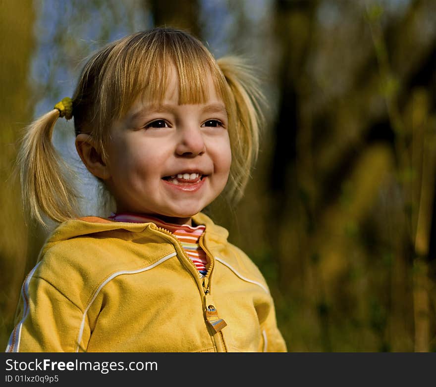 The little girl in spring park looks at a sunset. The little girl in spring park looks at a sunset