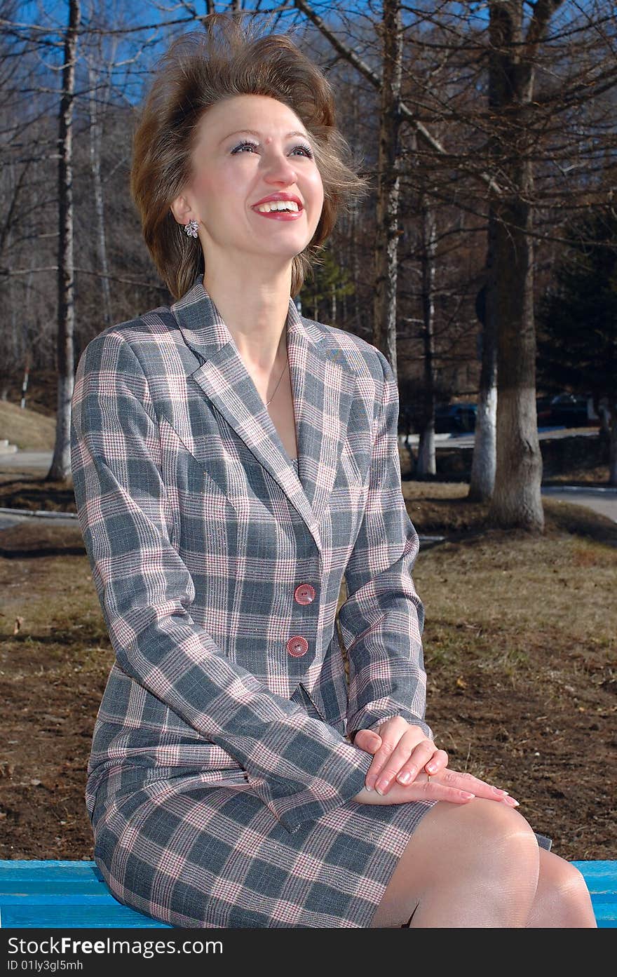 Stylish young woman sit on the bench.