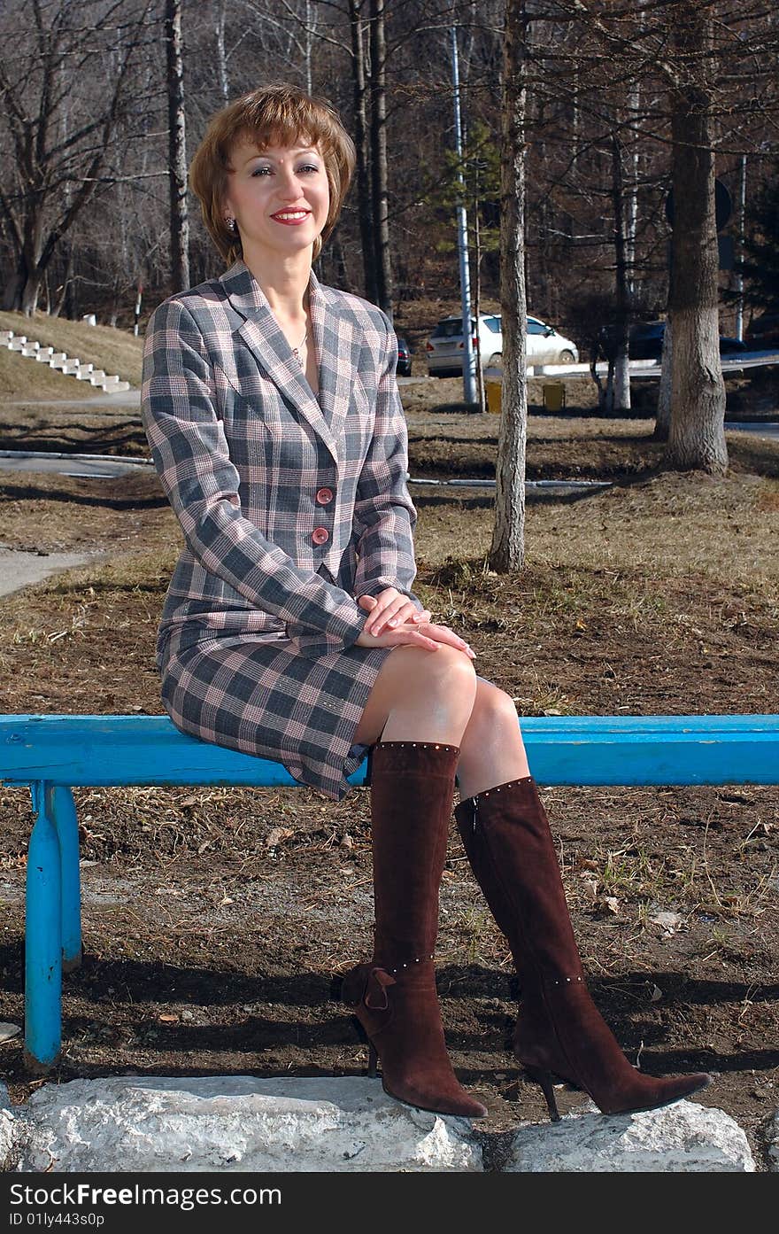 Stylish young woman sit on the bench.