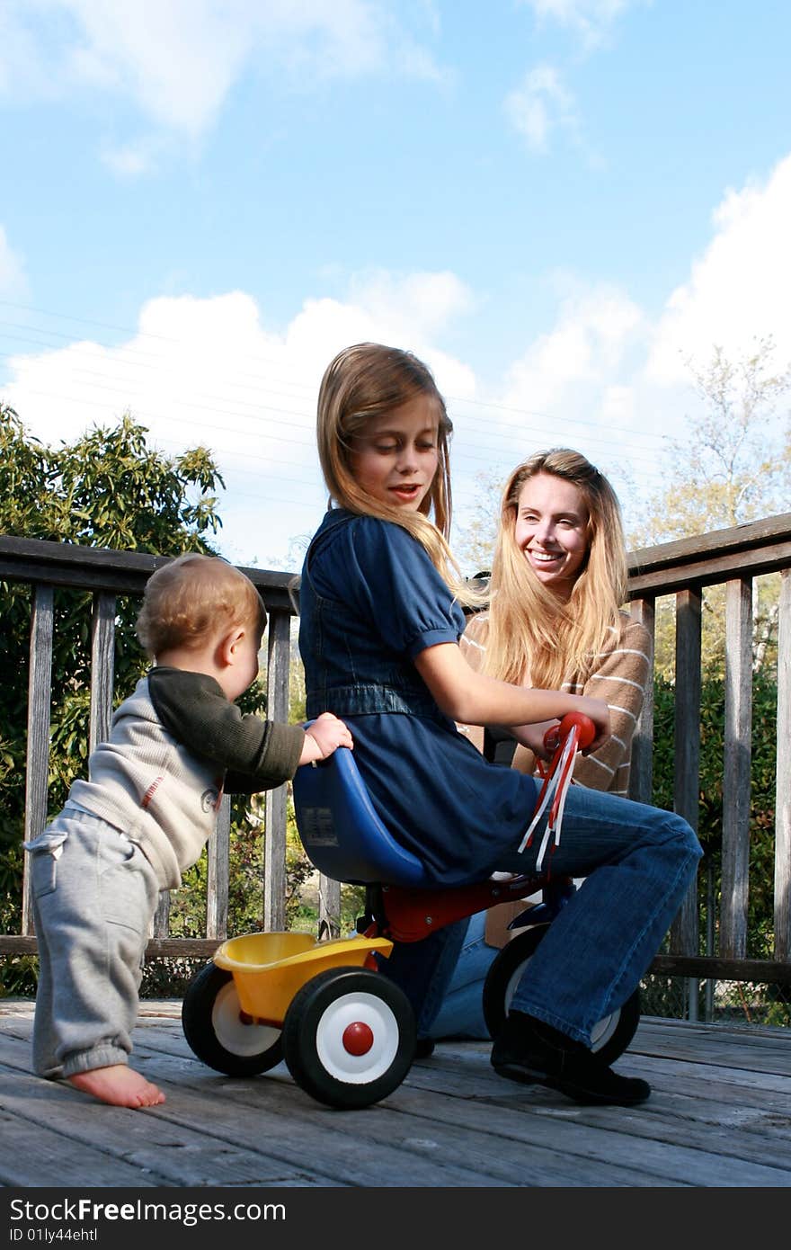 Cute little boy and his sister playing with mother watching. Cute little boy and his sister playing with mother watching