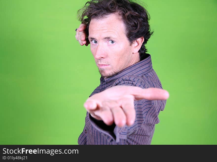 Young man doing some martial art movement on green background