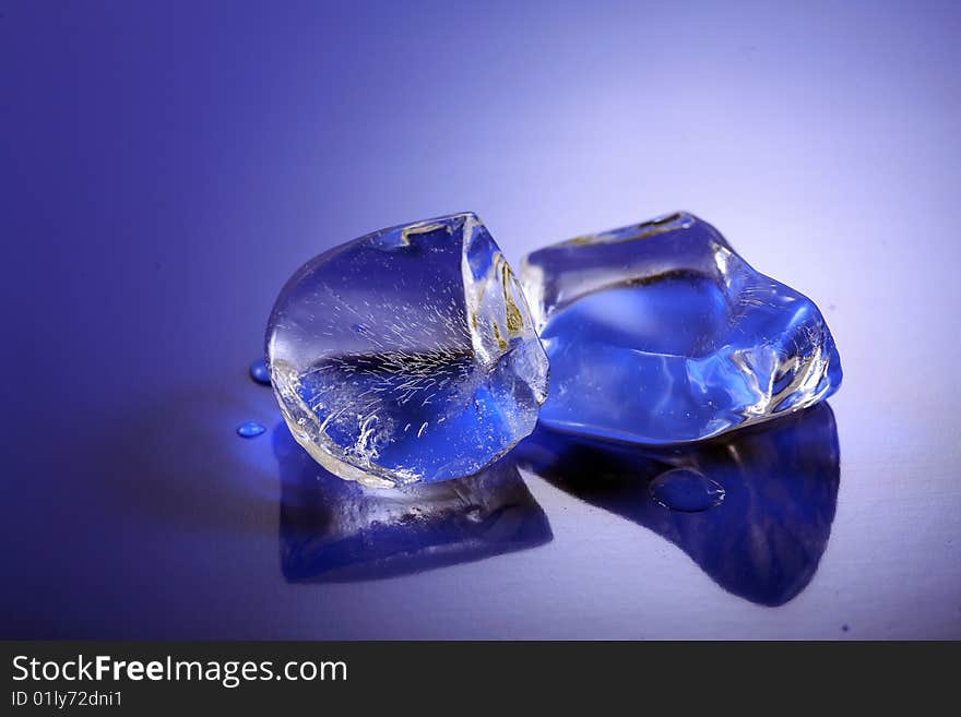 A image of Blue toned ice cubes on blue surface.