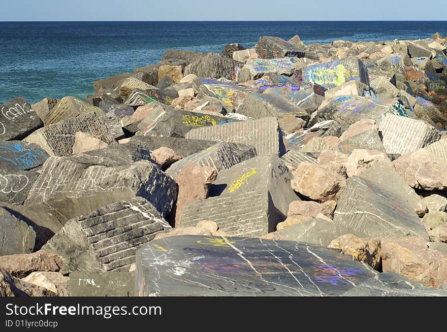 Breakwater painted graffiti on a day with clear sky