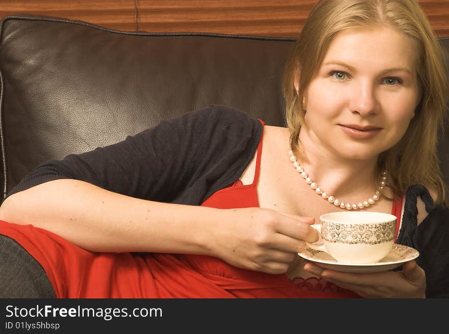 Beautiful young woman enjoying a cup of tea. Beautiful young woman enjoying a cup of tea