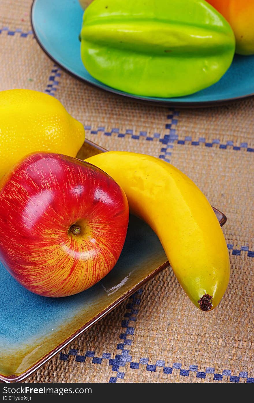 Two plates of fruits on a table. Two plates of fruits on a table