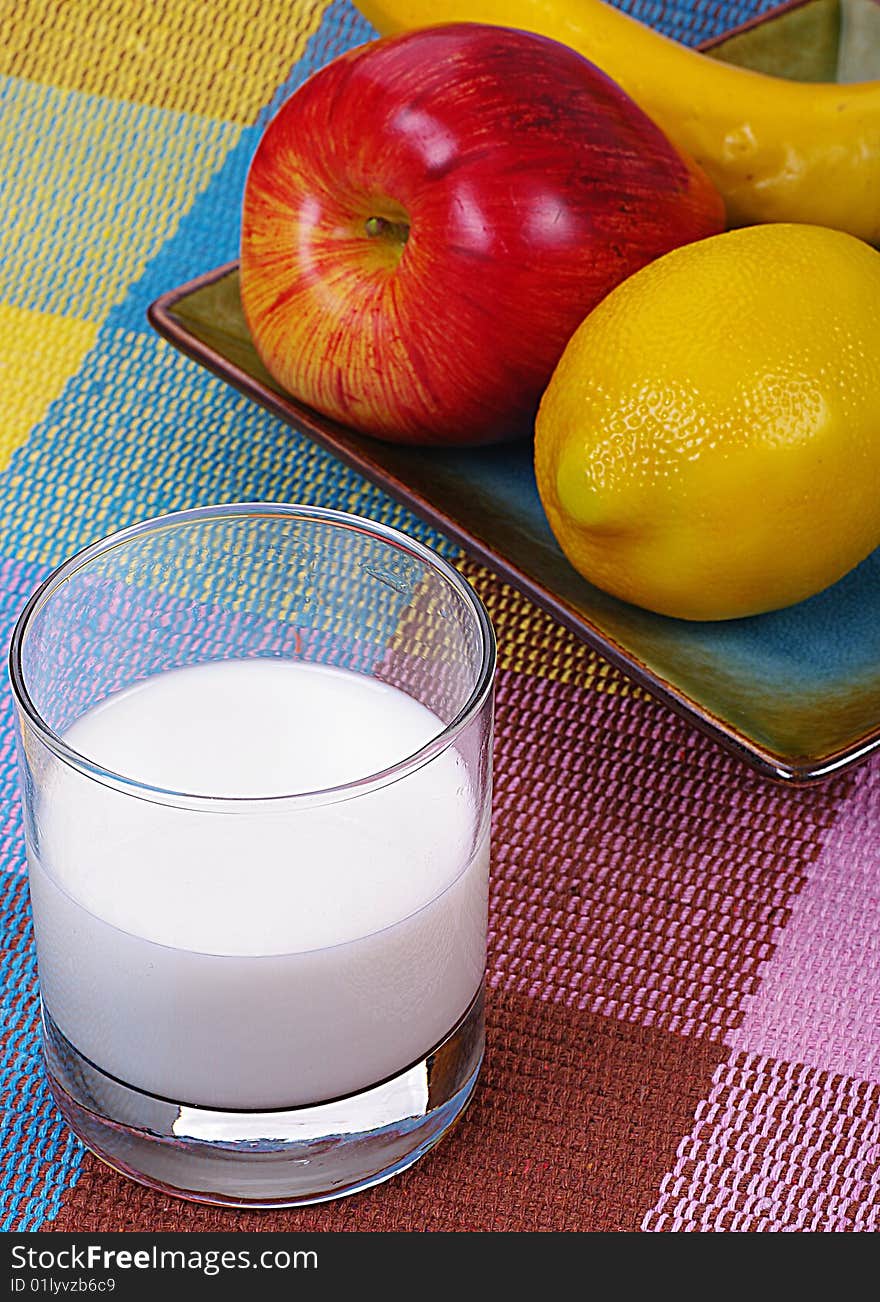 A bunch of fruits and a glass of milk. A bunch of fruits and a glass of milk