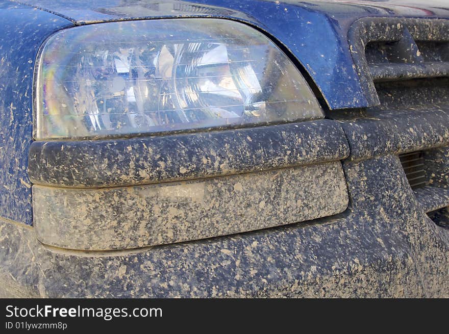 Mud on the front of a blue car