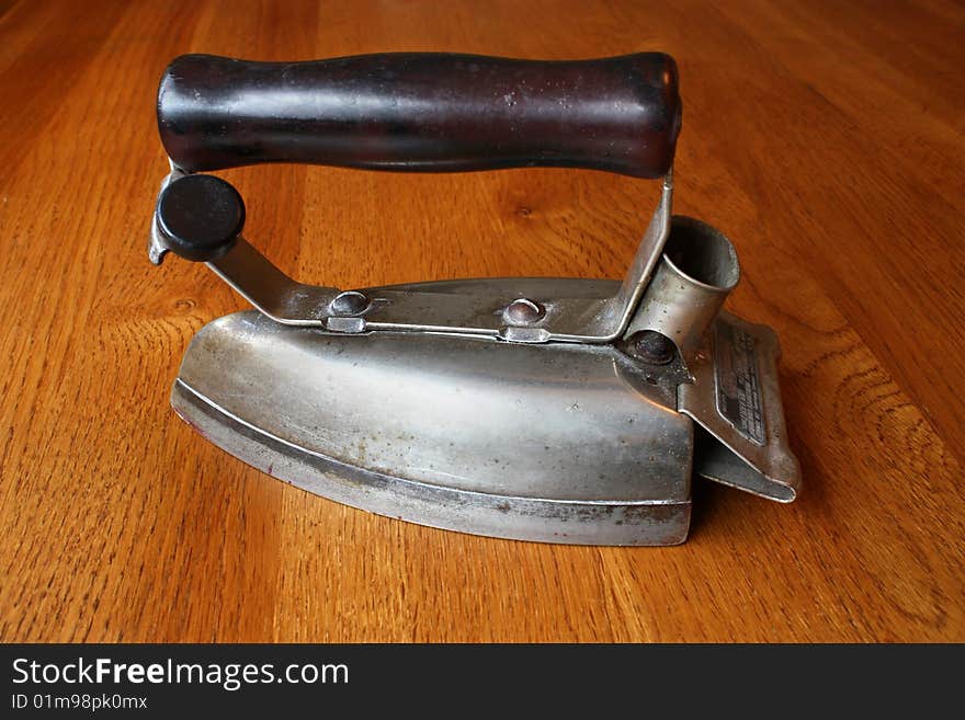 An old electric iron on a wooden background