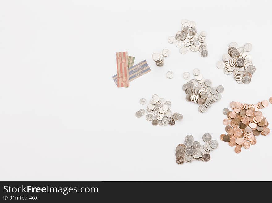 Piles of various coins and wrappers for organizing on white background. Piles of various coins and wrappers for organizing on white background