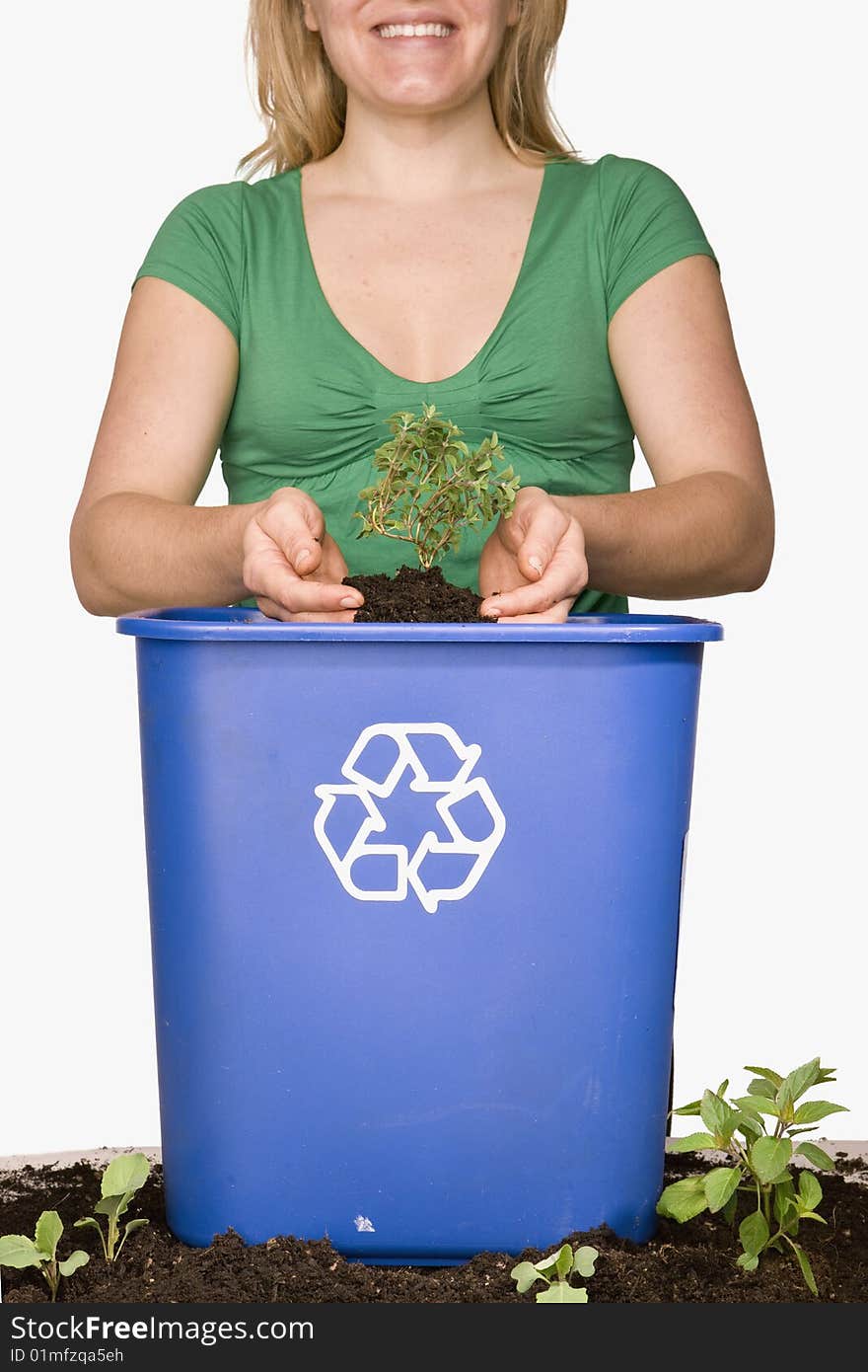 Woman holding small tree over recycling bin. Woman holding small tree over recycling bin