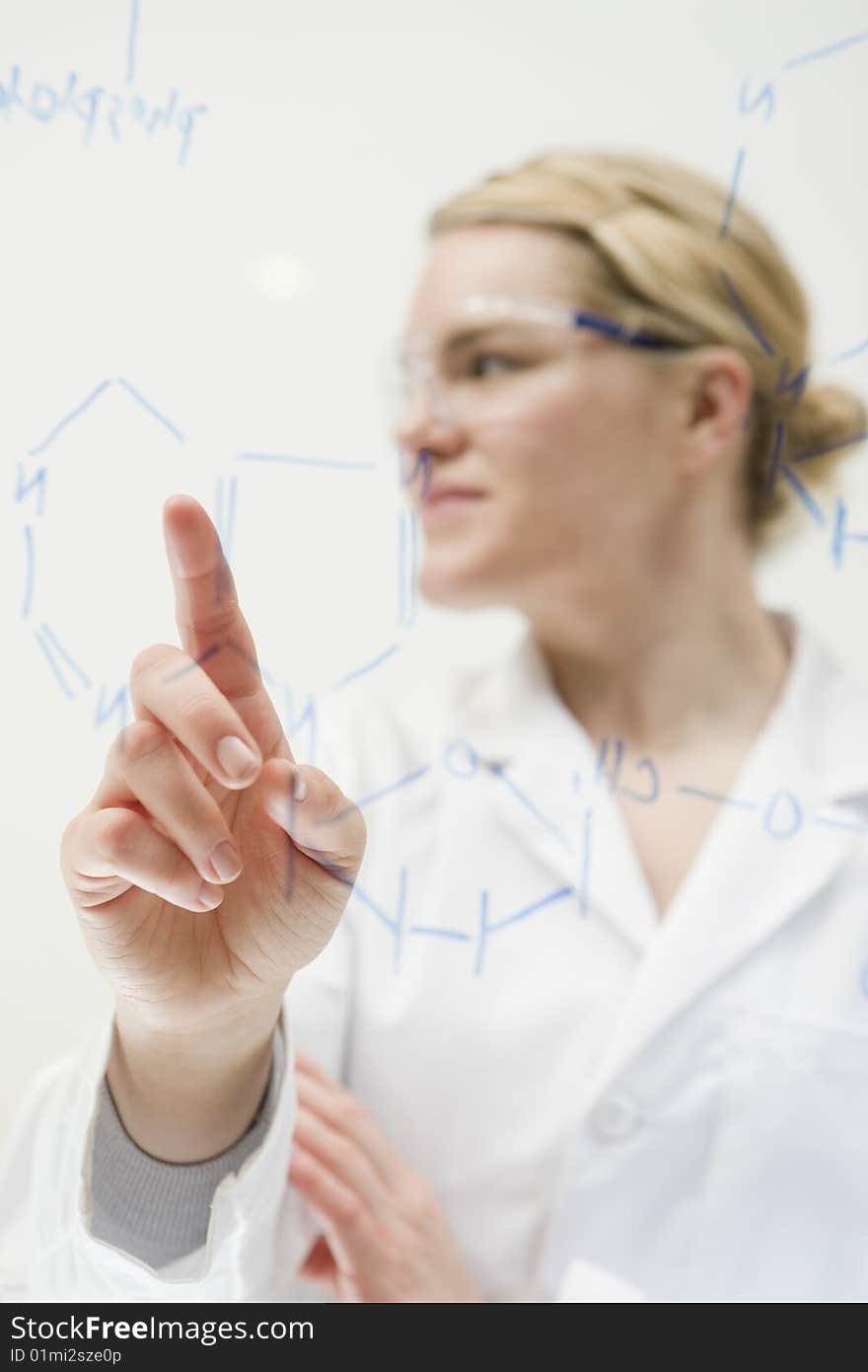 Female scientist working molecular formula on white board. Female scientist working molecular formula on white board