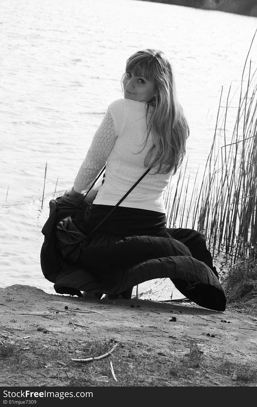 Beautiful female model on the lake with wind over her skirt