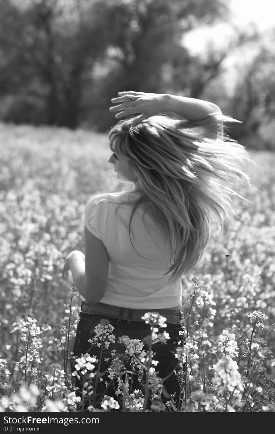 Beautiful female model plays with the wind on a meadow. Beautiful female model plays with the wind on a meadow