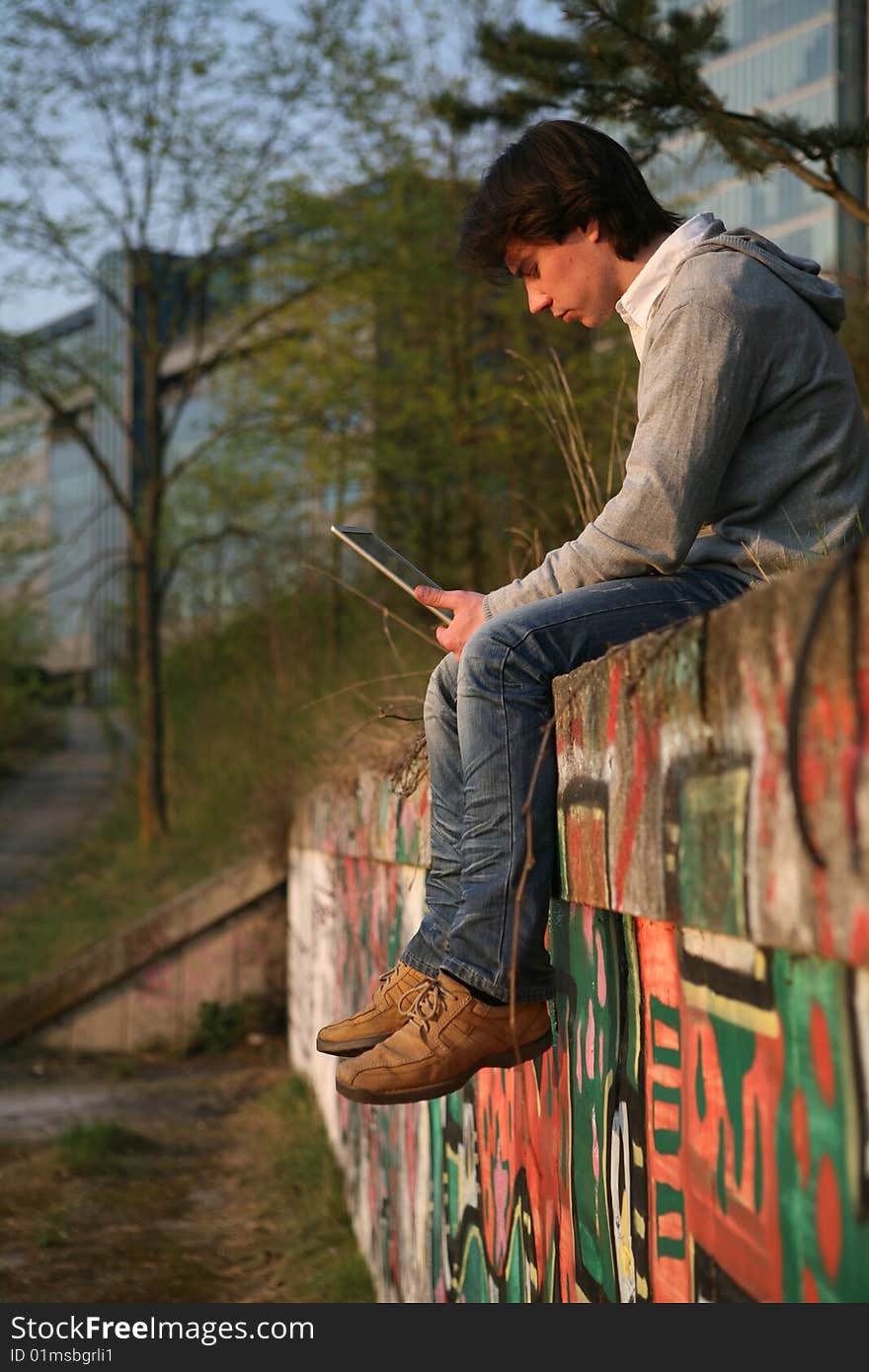 Young man working on a laptop outside. Young man working on a laptop outside.