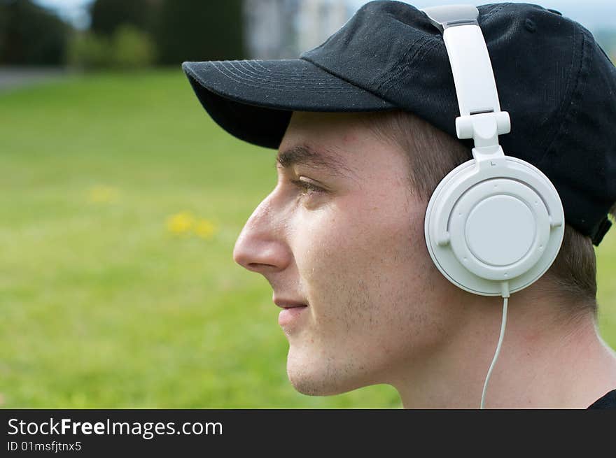 Student wearing a baseball cap & a headphones. Student wearing a baseball cap & a headphones