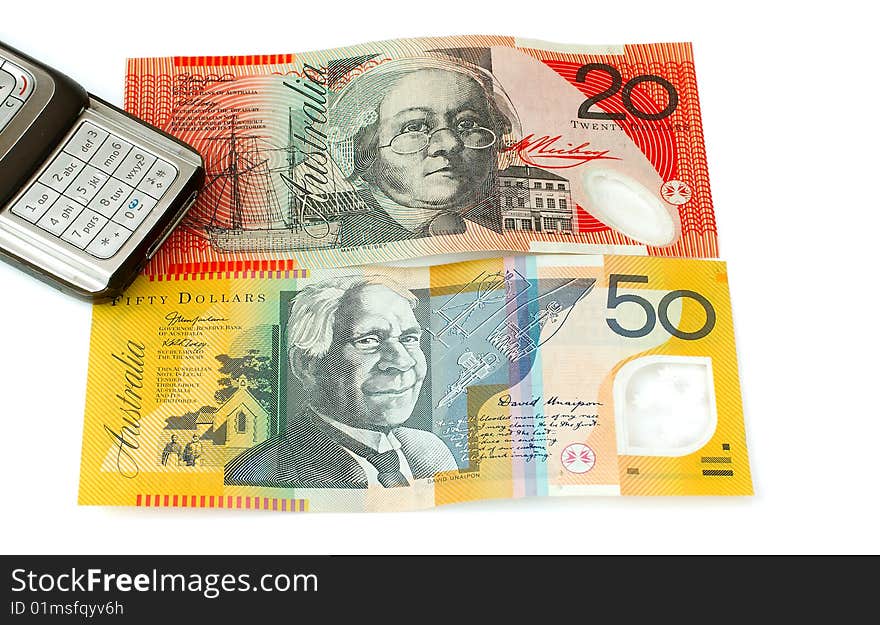 Mobile or cell phone next to Australian fifty and twenty dollar notes depicting the high costs of using a mobile telephone. Mobile or cell phone next to Australian fifty and twenty dollar notes depicting the high costs of using a mobile telephone