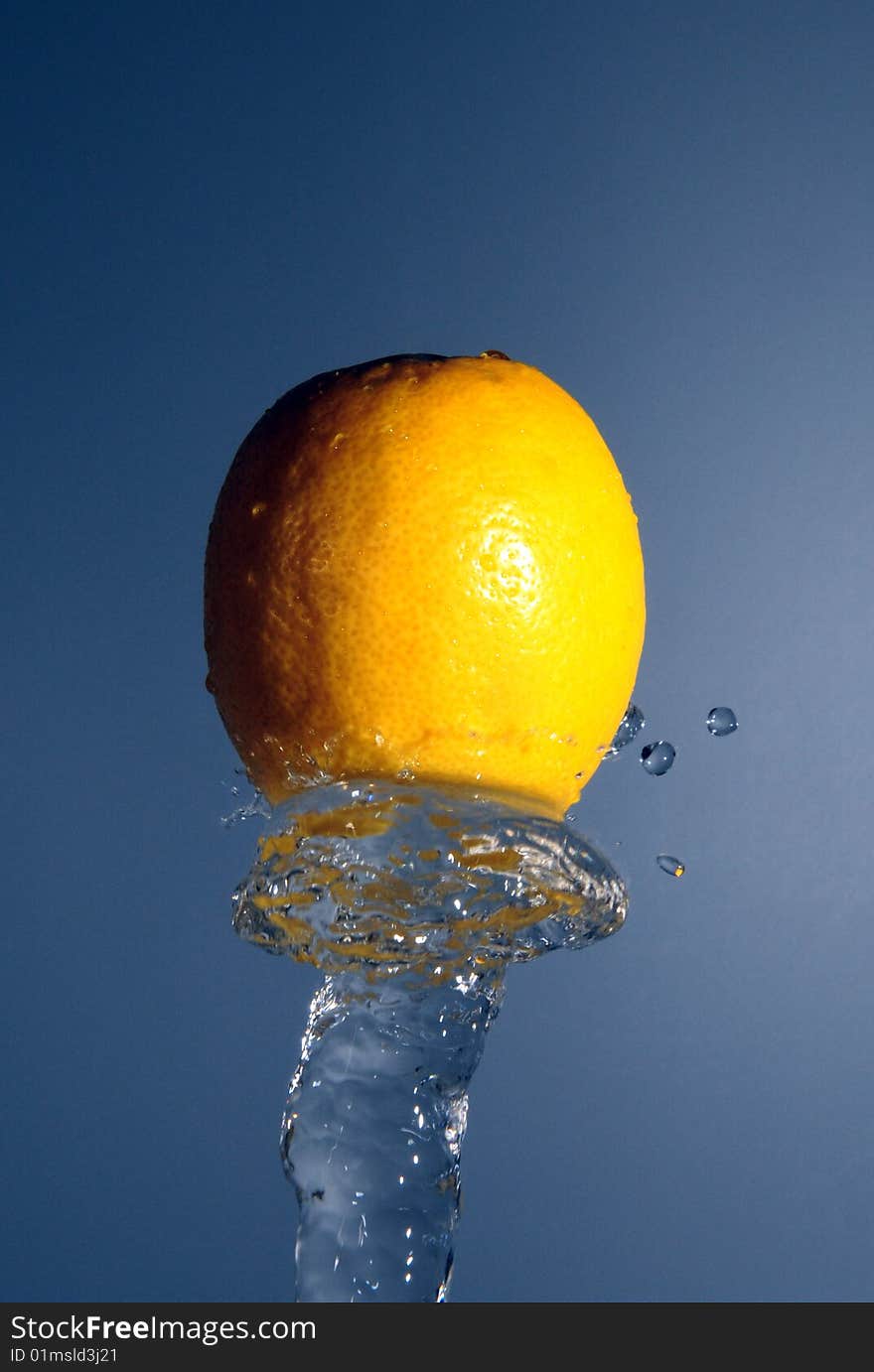 Lemon on the top of water stream on the blue background. Lemon on the top of water stream on the blue background