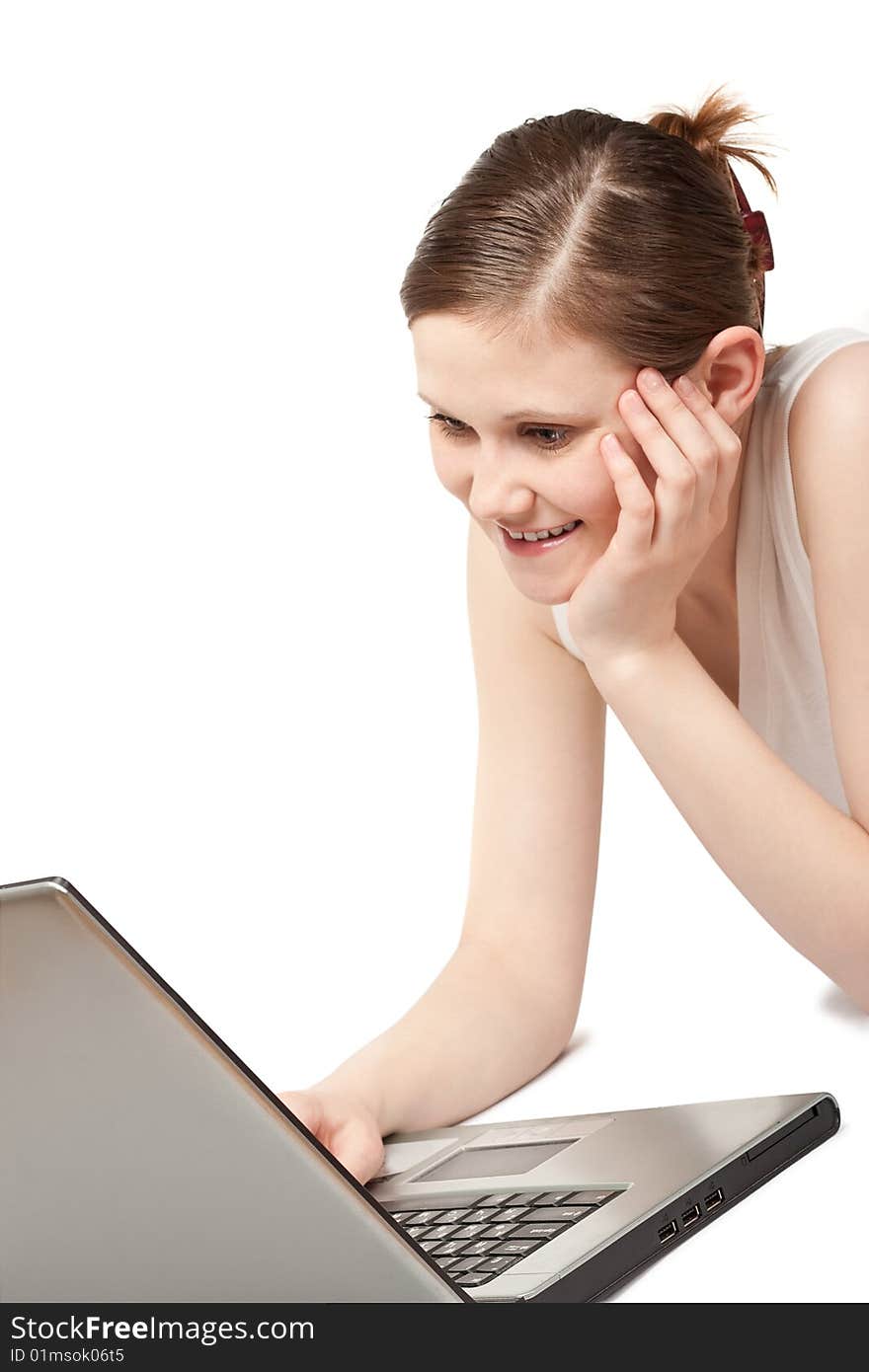 Laying young adult woman working with laptop. Laying young adult woman working with laptop