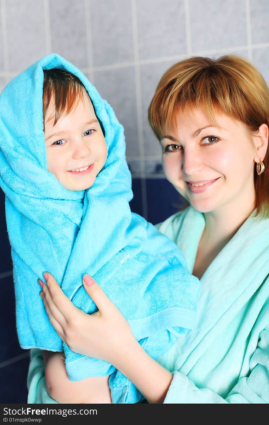 Portrait of a happy mother with her son after bath.