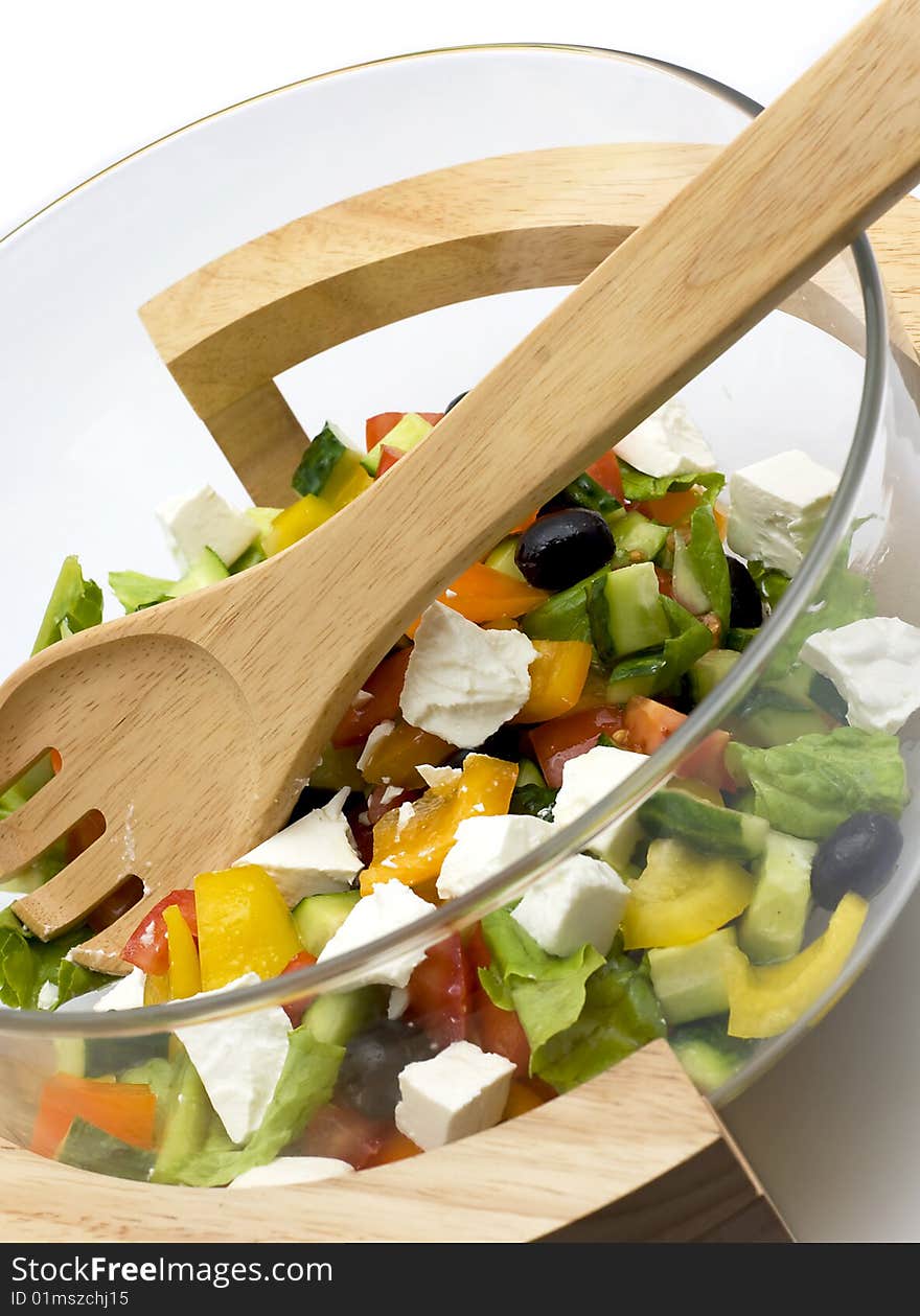 Bowl with vegetable salad and a wooden spoon