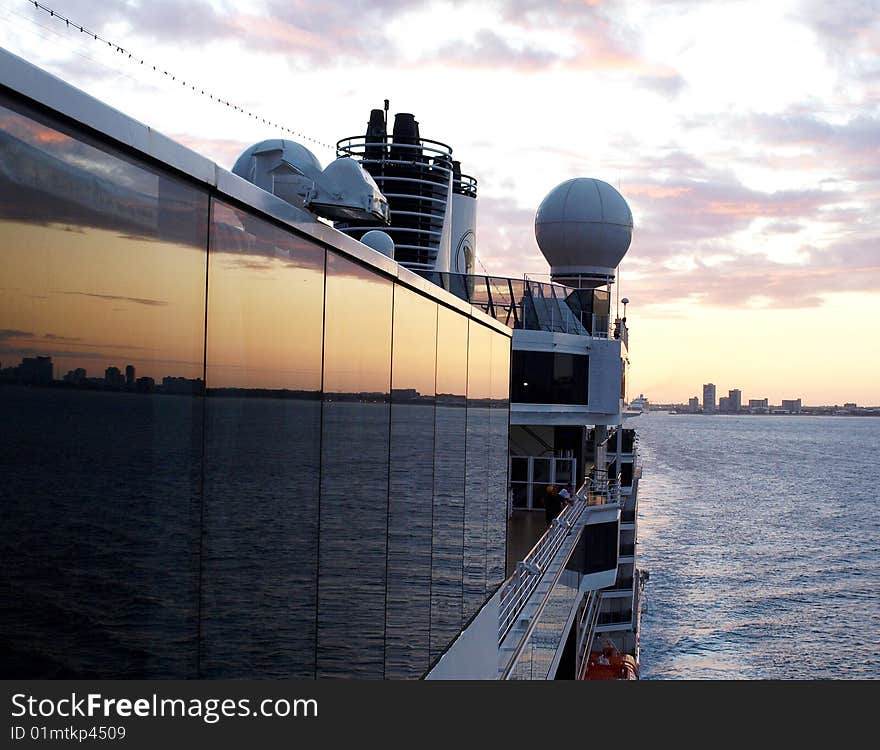 Cruise ship leaving port at sunset.