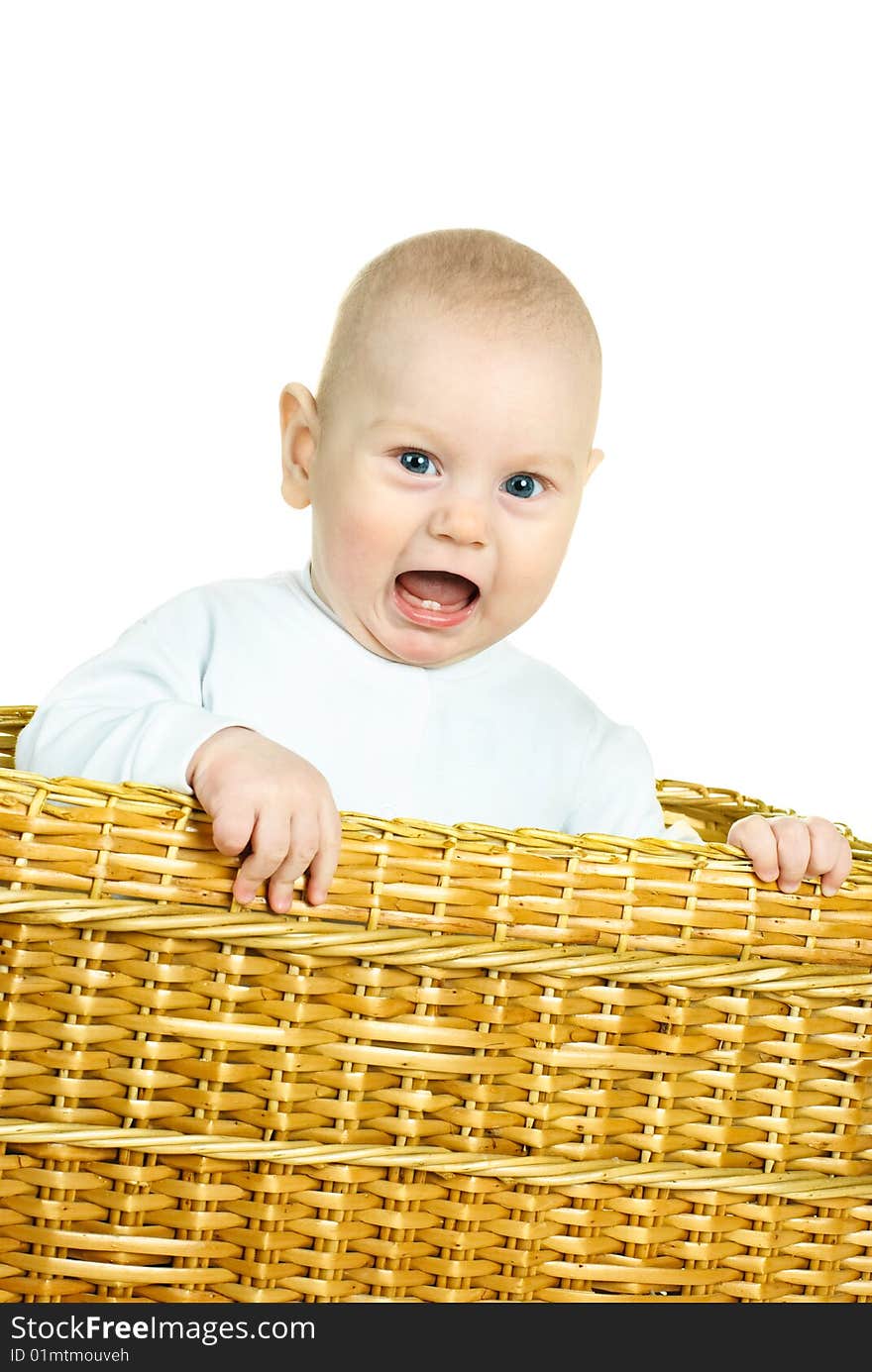 Cute six months old displeased baby boy sitting in the basket