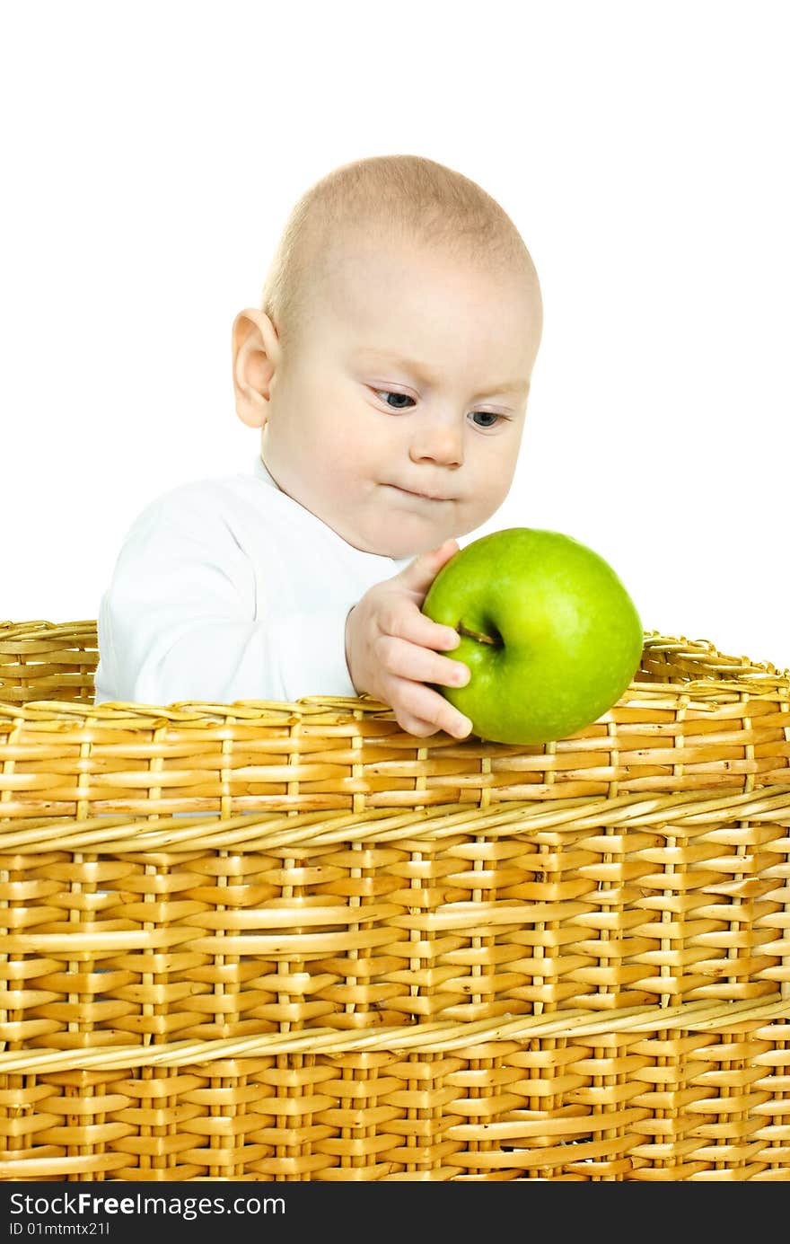 Cute six months old baby boy sitting in the basket and holding a green apple. Cute six months old baby boy sitting in the basket and holding a green apple