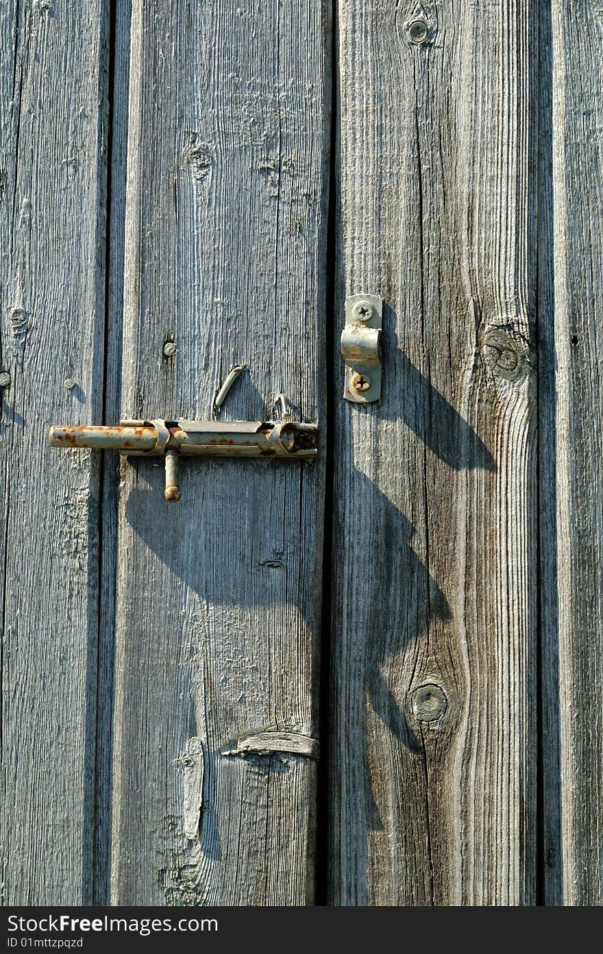 Old rusty handle on the wooden door