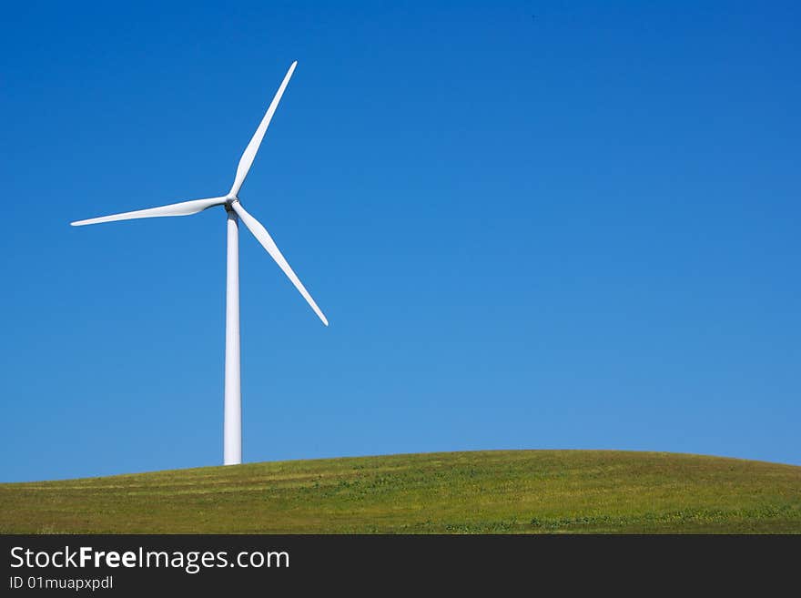 Windmill with fresh green grass and clear blue sky in summer. Windmill with fresh green grass and clear blue sky in summer