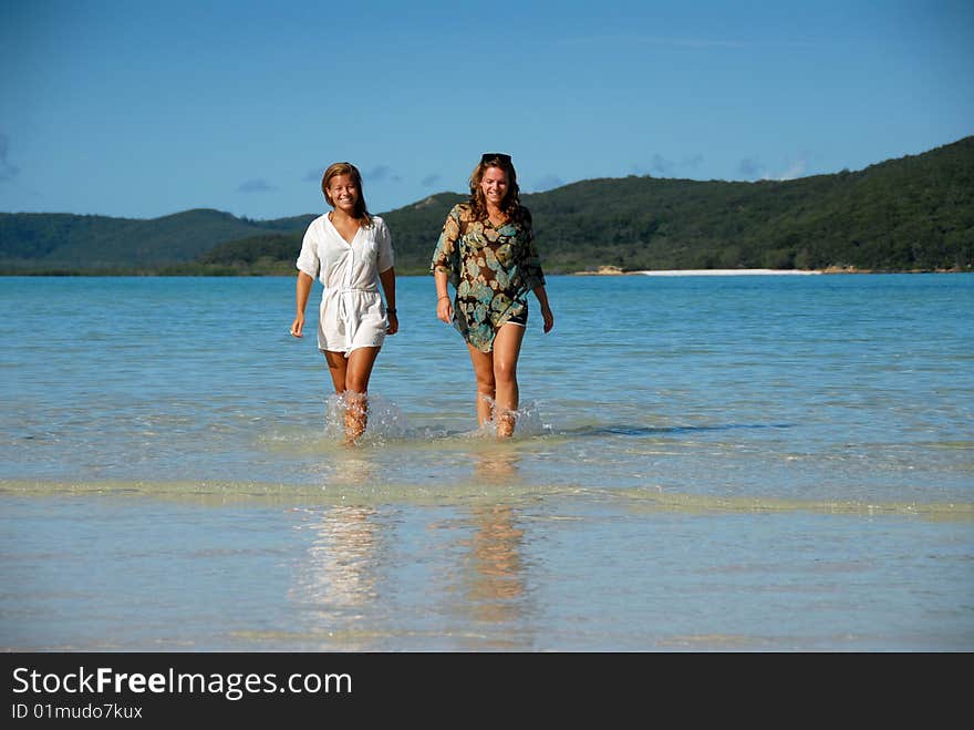 Two Young Women Walking Out Of Ocean