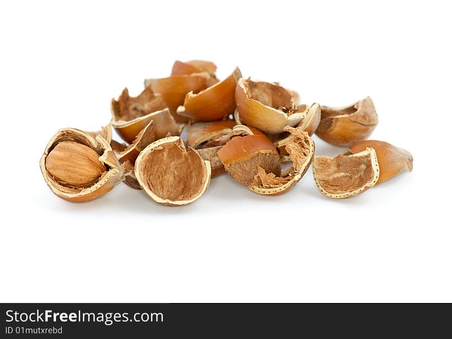 Small pile of hazelnuts shells and one cracked isolated on the white background